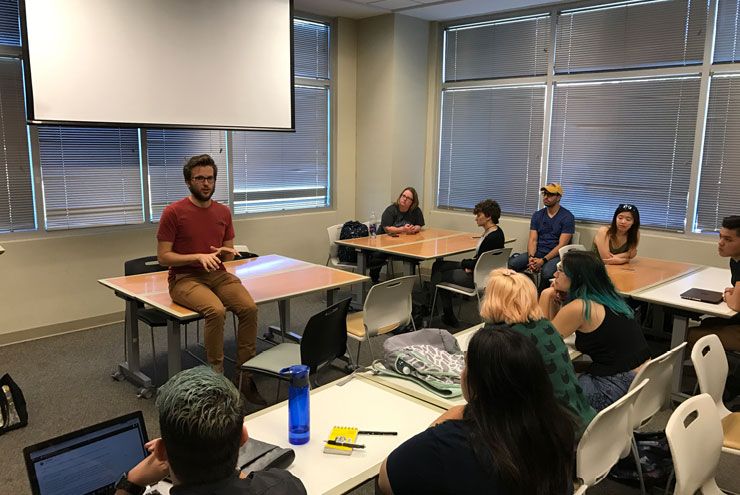 Photo of Spectrum South writer Josh Inocencio talks with college students about identity. 